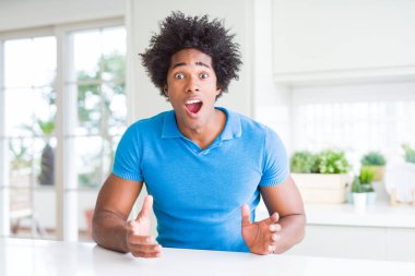 Afrika kökenli Amerikalı adam evde korkuyor ve sürpriz ifade ile şok korku ve yüz heyecanlı.