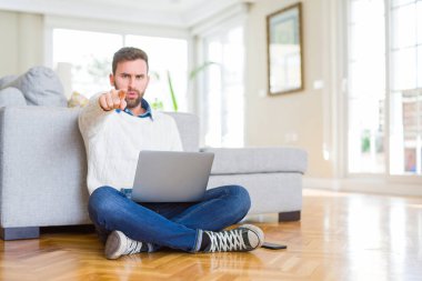 Yakışıklı adam giyen işareti, pozitif ve kendinden emin bir jest ön el bilgisayar laptop kamera ve size, parmak ile işaret kullanarak çalışma