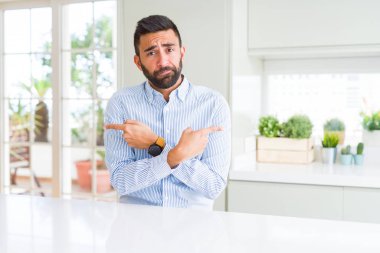 Yakışıklı İspanyol iş adamı işaret parmaklarıyla, farklı yönde iki tarafa da aynı fikirde.