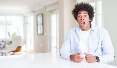 Afrika kökenli Amerikalı adam evde korkuyor ve sürpriz ifade ile şok korku ve yüz heyecanlı.