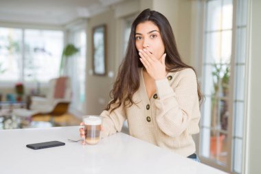Genç kadın için hata, ifade korku, utanç ile kapak ağız el ile şok kahve evde içme sessizlik içinde gizli kavramı korkuttu