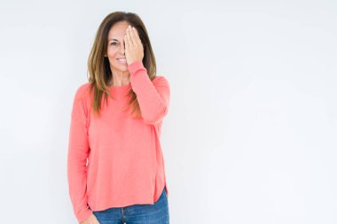 El yüz ve sürpriz duygu kendinden emin gülümseme ile tek gözüyle kapsayan izole arka plan güzel orta yaş kadın.