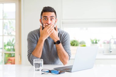 Bilgisayar dizüstü eller için hata ile ağız kapsayan şok kullanarak çalışan yakışıklı İspanyol adam. Gizli kavramı.