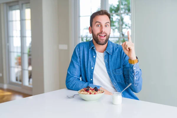 Όμορφος Άνθρωπος Τρώει Δημητριακά Για Πρωινό Στο Σπίτι Δείχνει Δάχτυλο — Φωτογραφία Αρχείου