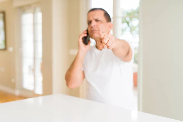 Hombre Mediana Edad Llamando Con Teléfono Inteligente Apuntando Con Dedo —  Fotos de Stock