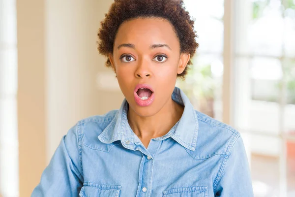 Young beautiful african american woman afraid and shocked with surprise expression, fear and excited face.