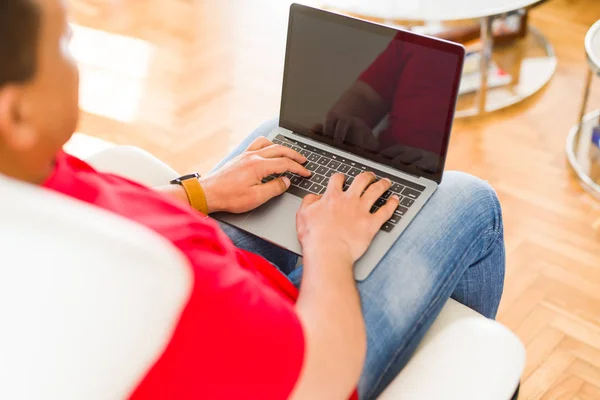 Średnim wieku człowiek za pomocą laptopa, siedząc na kanapie w domu — Zdjęcie stockowe