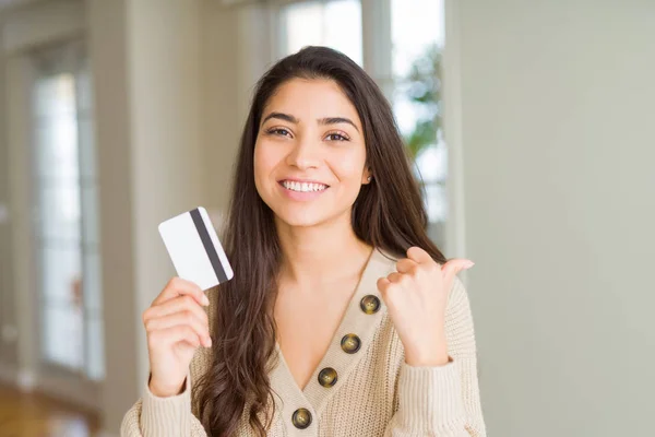 Junge Frau Hält Kreditkarte Als Zahlungsmittel Und Zeigt Mit Dem — Stockfoto