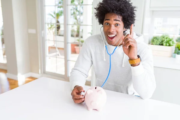 Homem Afro Americano Segurando Estetoscópio Verificando Saúde Financeira Mealheiro Surpreso — Fotografia de Stock