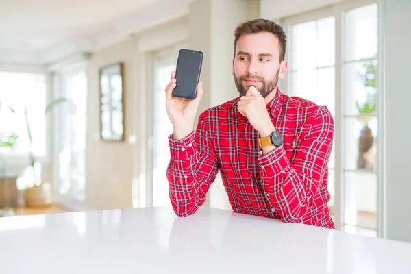 Pohledný Muž Ukazuje Smartphone Obrazovky Vážná Tvář Přemýšlet Otázku Velmi — Stock fotografie