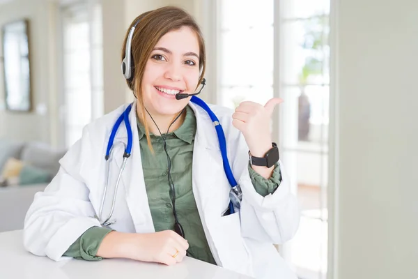 Hermosa Joven Doctora Con Auriculares Sonriendo Con Cara Feliz Mirando — Foto de Stock