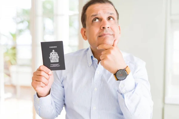 Średnim Wieku Człowiek Trzyma Trzyma Kanadyjski Paszport Poważny Wyraz Twarzy — Zdjęcie stockowe