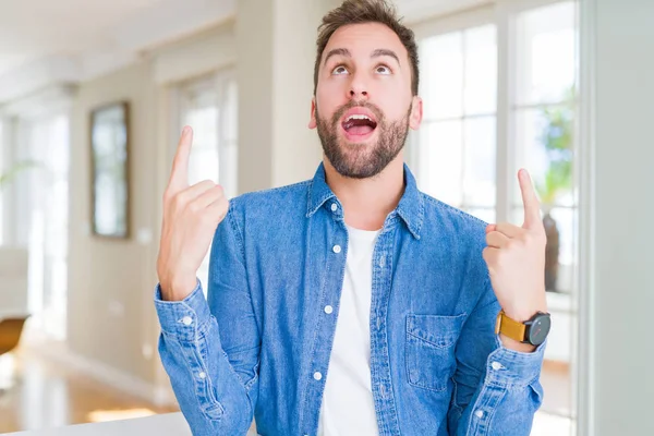 Hombre Guapo Casa Asombrado Sorprendido Mirando Hacia Arriba Señalando Con — Foto de Stock