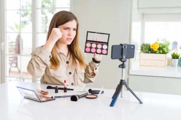 Beautiful young influencer woman recording make up video tutorial annoyed and frustrated shouting with anger, crazy and yelling with raised hand, anger concept