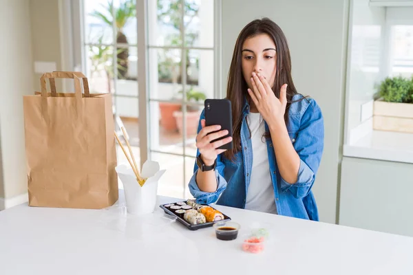 美丽的年轻女子订购食品交付从应用程序使用智能手机封面嘴与手震惊的错误 表达恐惧 害怕在沉默中 秘密的概念 — 图库照片