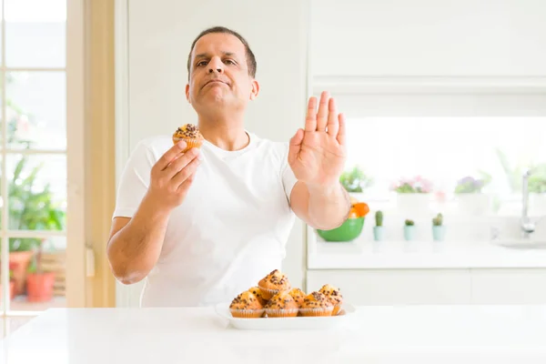 Homem Meia Idade Comendo Muffins Chocolate Casa Com Mão Aberta — Fotografia de Stock