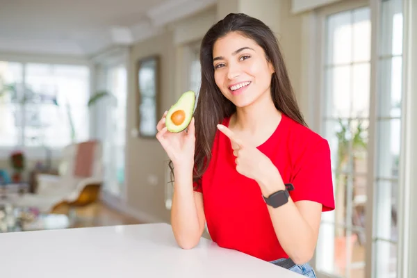 Mujer Joven Comiendo Aguacate Saludable Muy Feliz Señalando Con Mano —  Fotos de Stock