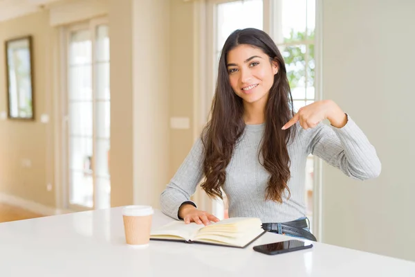 Mujer Joven Leyendo Libro Bebiendo Café Con Cara Sorpresa Señalándose —  Fotos de Stock