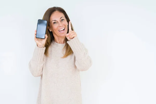 Frau Mittleren Alters Zeigt Smartphone Bildschirm Über Isoliertem Hintergrund Überrascht — Stockfoto