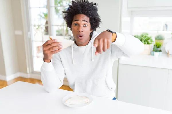 Hombre Afroamericano Comiendo Sándwich Hecho Mano Casa Señalando Con Dedo — Foto de Stock