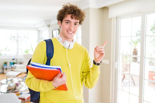 Joven Estudiante Con Auriculares Mochila Sosteniendo Cuadernos Muy Feliz Señalando —  Fotos de Stock