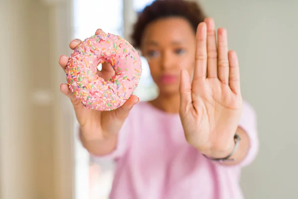 Mujer Afroamericana Joven Comiendo Rosado Azúcar Donut Con Mano Abierta —  Fotos de Stock