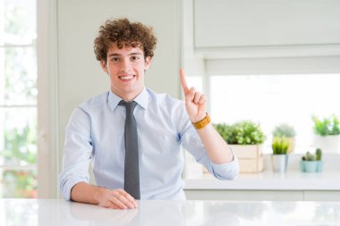 Ve parmak gülümseyen süre bir numara ile kendinden emin ve mutlu yukarıyı gösteren bir kravat giyen genç iş adamı.