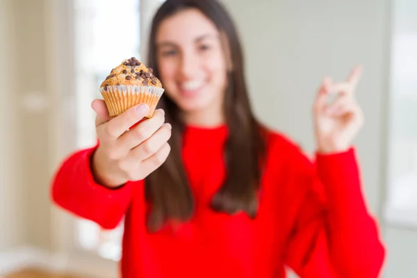 チョコチップ マフィン側の手と指で指す非常に幸せを食べて美しい若い女性 — ストック写真