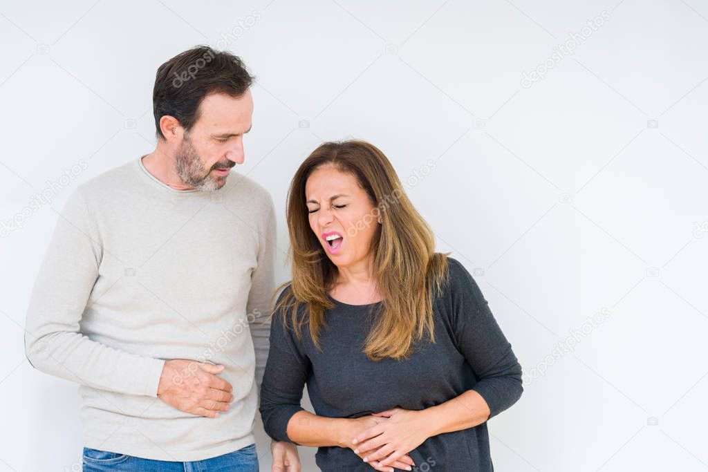 Beautiful middle age couple in love over isolated background with hand on stomach because indigestion, painful illness feeling unwell. Ache concept.