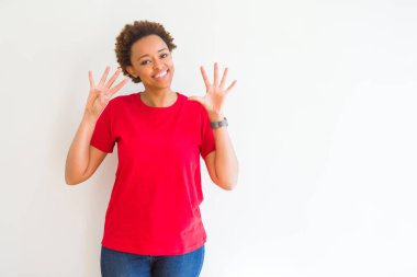 Gösterilen ve parmakları ile işaret beyaz arka plan üzerinde genç güzel bir Afrikalı-Amerikalı kadın numara 9 kendinden emin ve mutlu gülümseyerek süre.