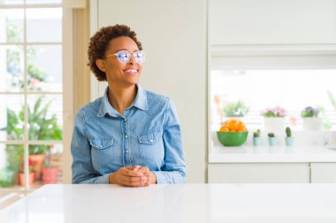 Uzak tarafına yüzünde, doğal ifade gülümseme ile seyir gözlüklü genç güzel Afrikalı-Amerikalı kadın. Kendine güvenen gülüyor.