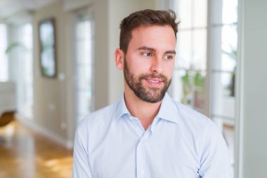 Yakışıklı iş adamı uzak tarafına yüzünde, doğal ifade gülümseme ile arıyorum. Kendine güvenen gülüyor.