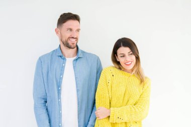 Genç güzel çift togheter izole arka plan uzak tarafına gülümseme ile yüzünde, doğal ifade seyir üzerinde. Kendine güvenen gülüyor.