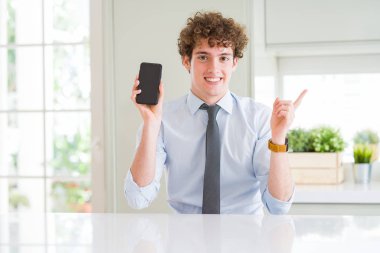 Genç iş adamı gösteren smartphone ekran el ve parmak ile tarafına işaret çok mutlu ofis