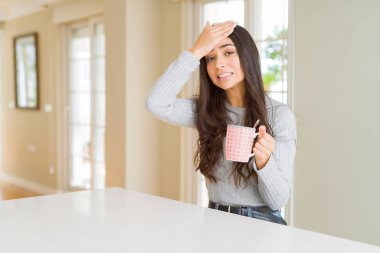 Genç kadın baş, el ile vurguladı kahve içme şok utanç ve sürpriz suratla, öfkeli ve sinirli. Korku ve hata için üzgün.