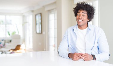 Afrika kökenli Amerikalı adam evde görünümlü yan ve dik dik bakma uzağa düşünce gülümseyen.