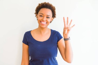 Gösterilen ve parmakları ile işaret beyaz arka plan üzerinde genç güzel bir Afrikalı-Amerikalı kadın kendinden emin ve mutlu gülümseyerek süre dört numara.