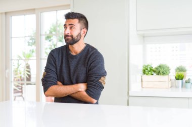 Yakışıklı İspanyol dostum eve görünümlü yan gülümseyen ve uzak düşünme bakıyordu giyen sıradan kazak.