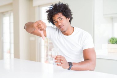 Afrika kökenli Amerikalı adam kızgın yüzü, eksi işareti aşağı antipati başparmak ile gösterilen, ret kavramı ile evde su içme