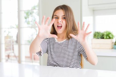 Güzel genç kız çocuk giyen şokta bağırarak t-shirt korkuyor ve dehşet korku ifade dur hareketi el ile ile çizgili. Panik kavramı.