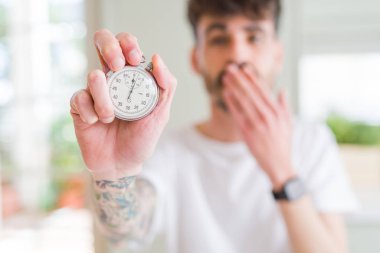 Genç adam kullanarak kronometre kapak ağız hata, korku, ifade için utanç ile şok eliyle tutarak korkuyor sessizlik içinde gizli kavramı