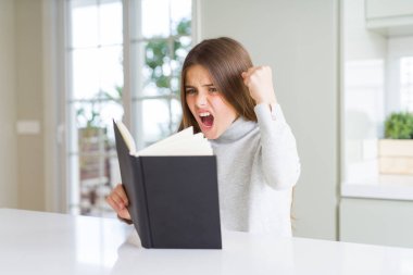 Güzel genç kız ev rahatsız ve hayal kırıklığı ile öfke, çılgın ve yükseltilmiş eliyle diye bağıran öfke kavramı bağırarak adlı bir kitap okuma