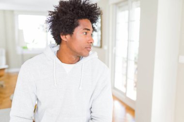 Afrika kökenli Amerikalı adam giyen kazak tarafına, seyir dinlenmek doğal yüz emin gülümseme ile pozuyla profil.