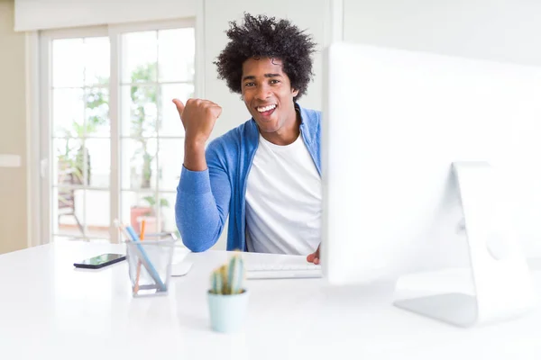 コンピューターを指して使用してアフリカ系アメリカ人の男と幸せそうな顔を笑顔で側まで親指で示す — ストック写真