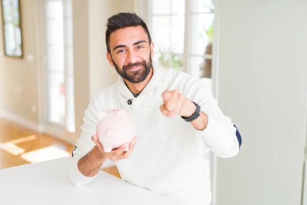Handsome Hispanic Man Holding Piggy Bank Pointing Finger Camera You — Stock Photo, Image