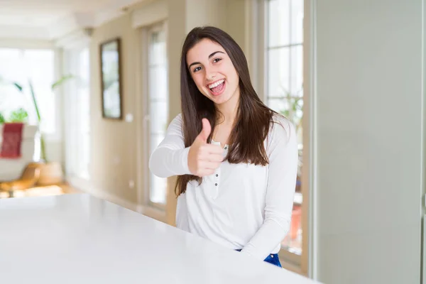 Beautiful Young Woman Sitting White Table Home Doing Happy Thumbs — Stock Photo, Image