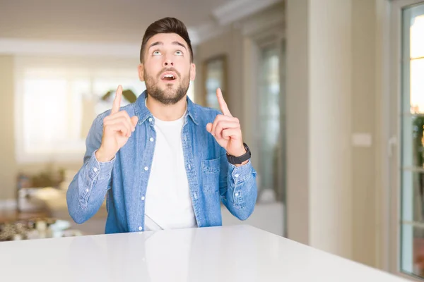 Joven Hombre Guapo Casa Asombrado Sorprendido Mirando Hacia Arriba Señalando — Foto de Stock