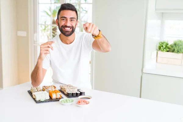 Przystojny Mężczyzna Hiszpanin Jedzenie Sushi Azjatycki Pomocą Pałeczki Wskazując Palcem — Zdjęcie stockowe