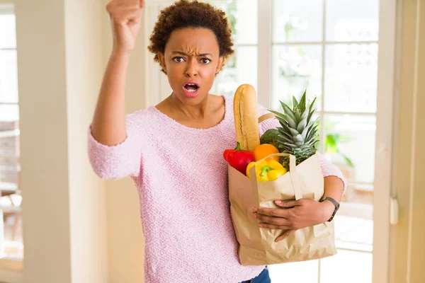 Joven Mujer Afroamericana Sosteniendo Bolsa Papel Llena Alimentos Frescos Molesto — Foto de Stock