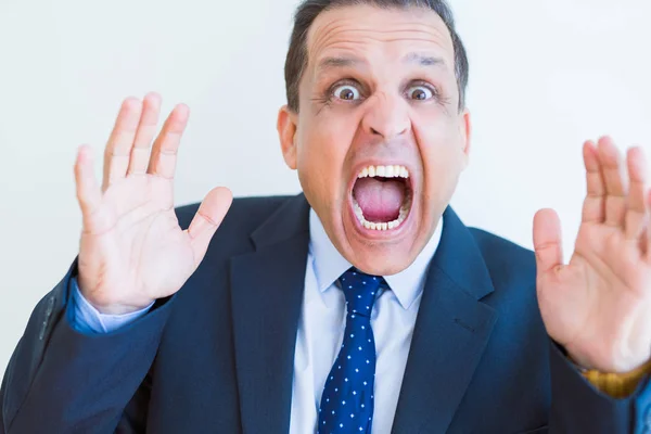 Homem de meia idade gritando louco com as mãos sobre a boca sobre branco w — Fotografia de Stock